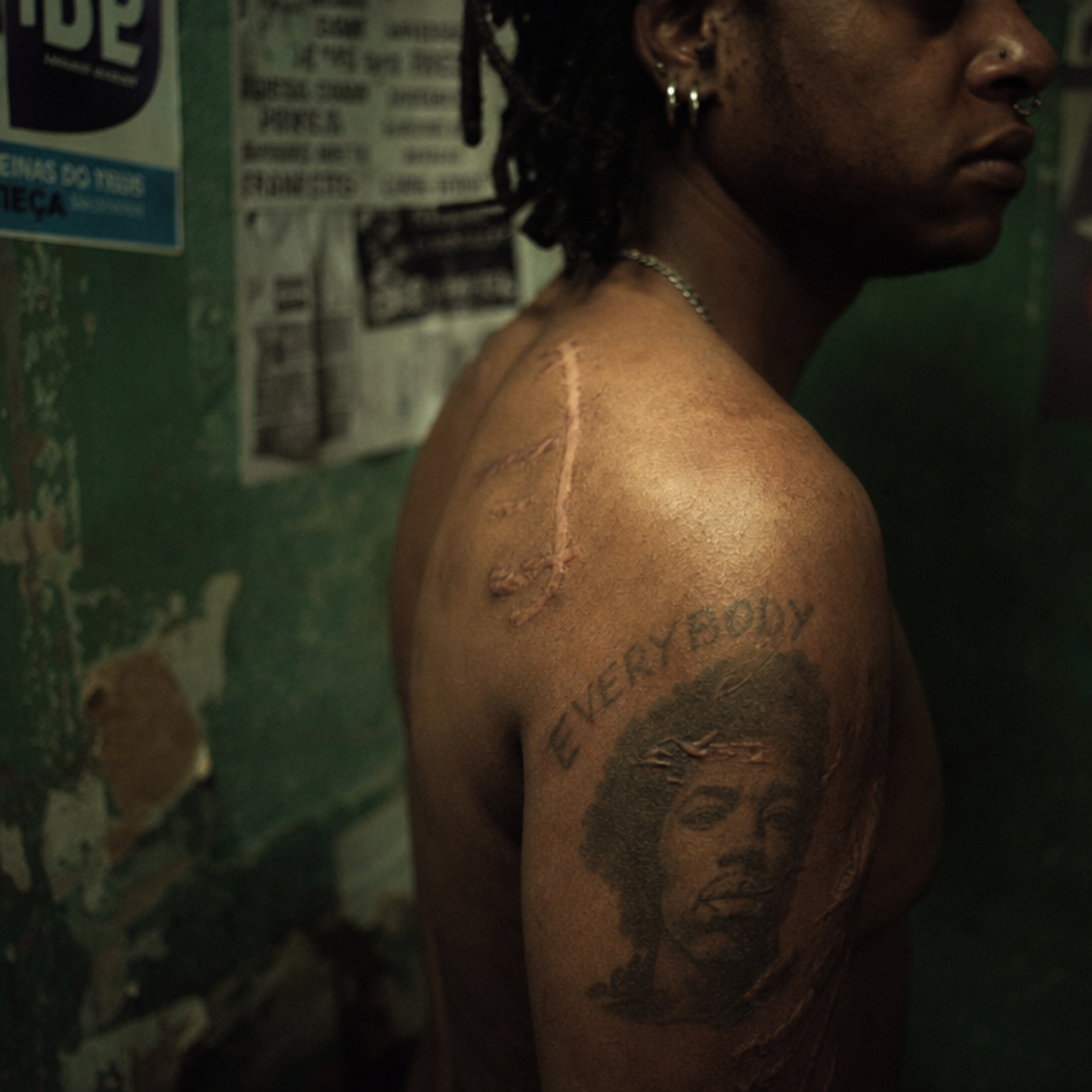 Cicatriz e tatuagem visíveis sobre o ombro